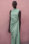 Modelo con el Baobab Vitto Maxi Dress color Jade posando frente a una pared de color rosa.