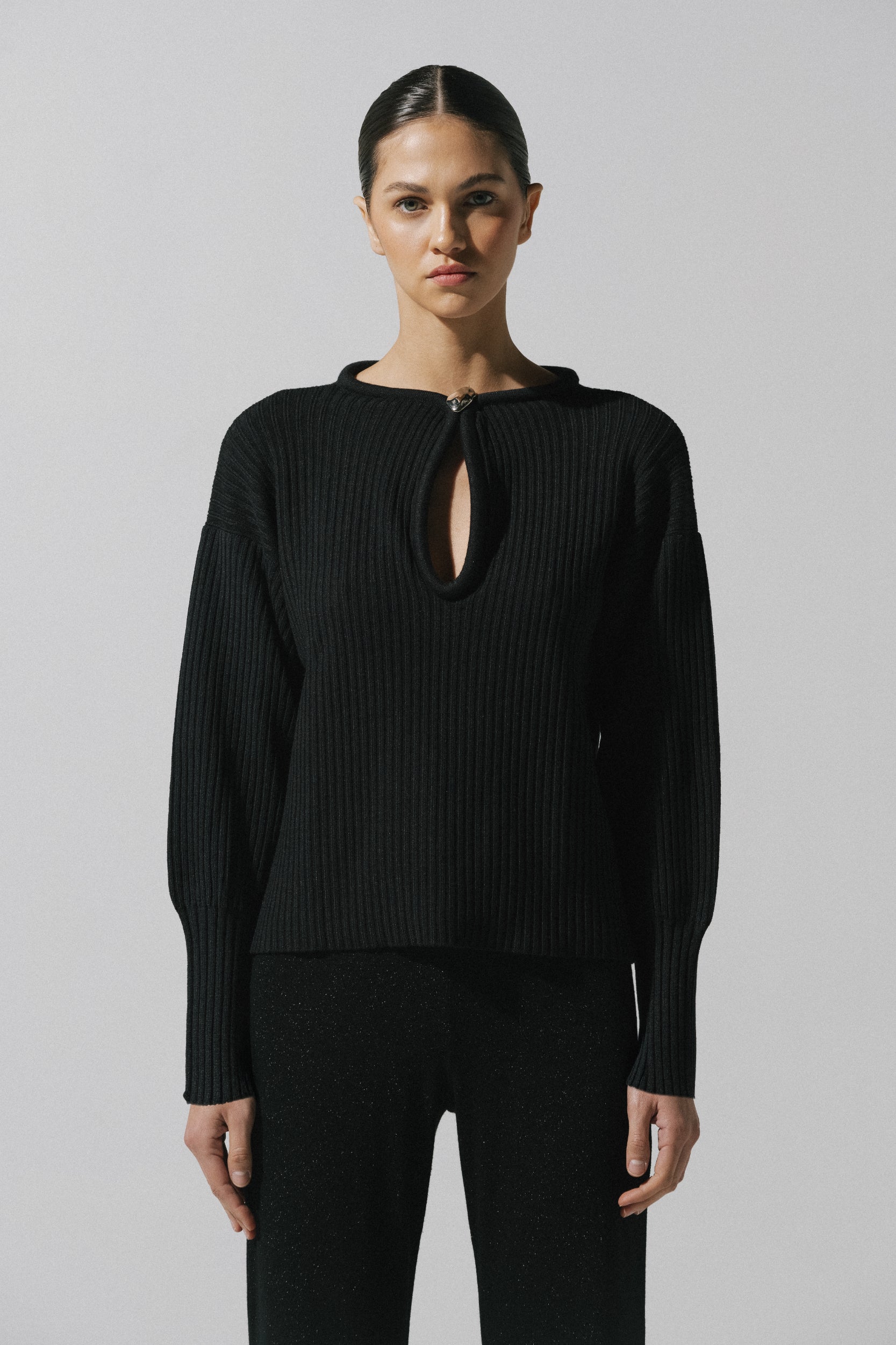 Sweater Akila de Baobab en color negro, cuello redondo con recortes frontales y herraje decorativo.