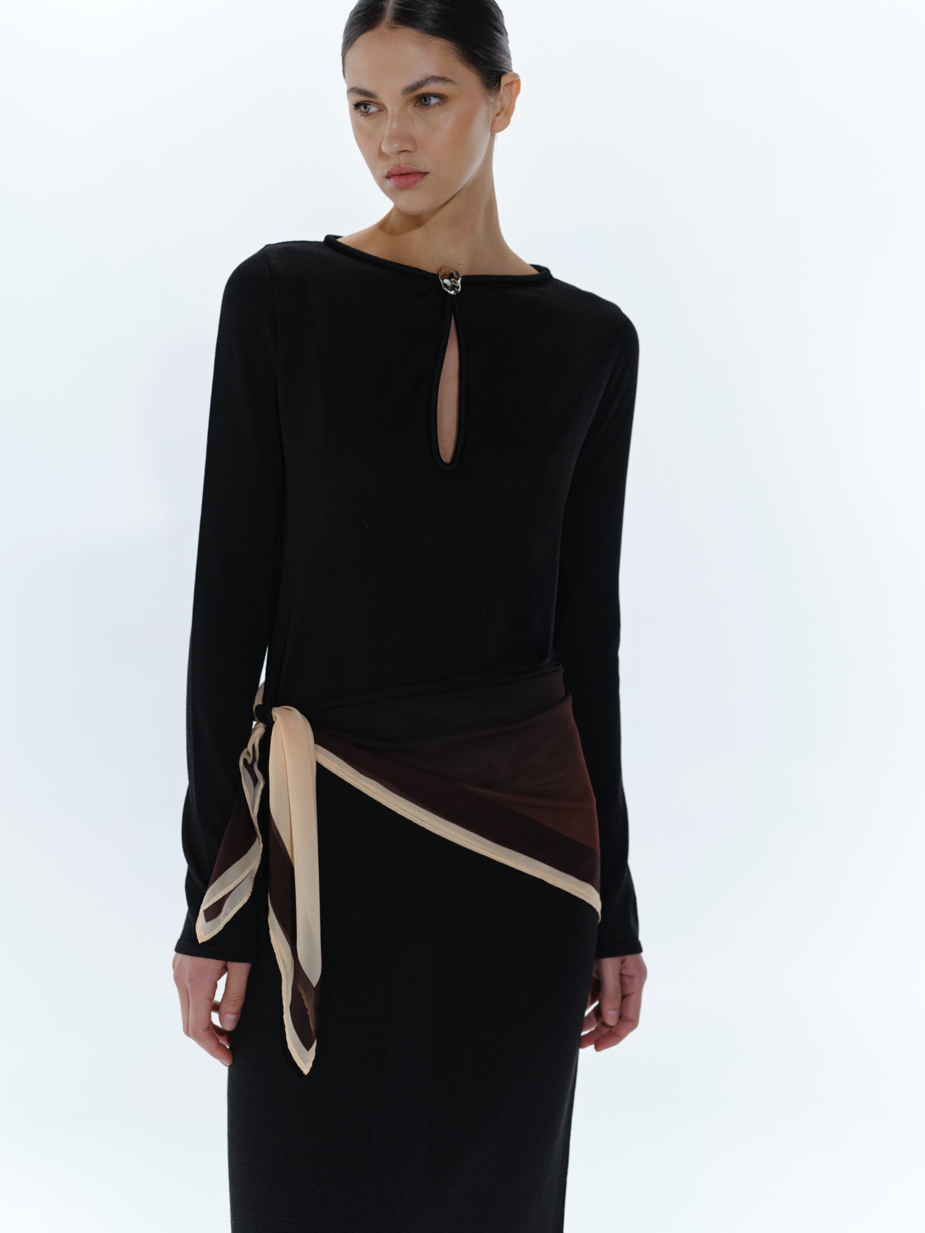 Vestido Ramila negro, detalle del escote redondo y herraje baobab en zona frontal.