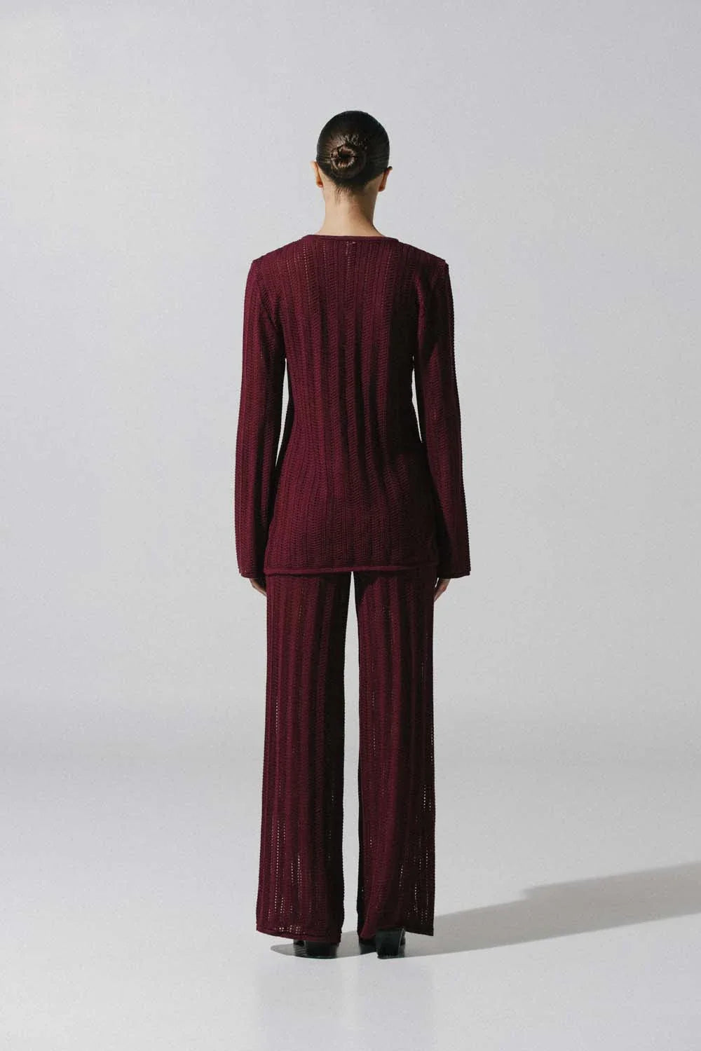 Detalle del pantalón Corsica de Baobab, tejido de punto semi transparente en color burgundy.