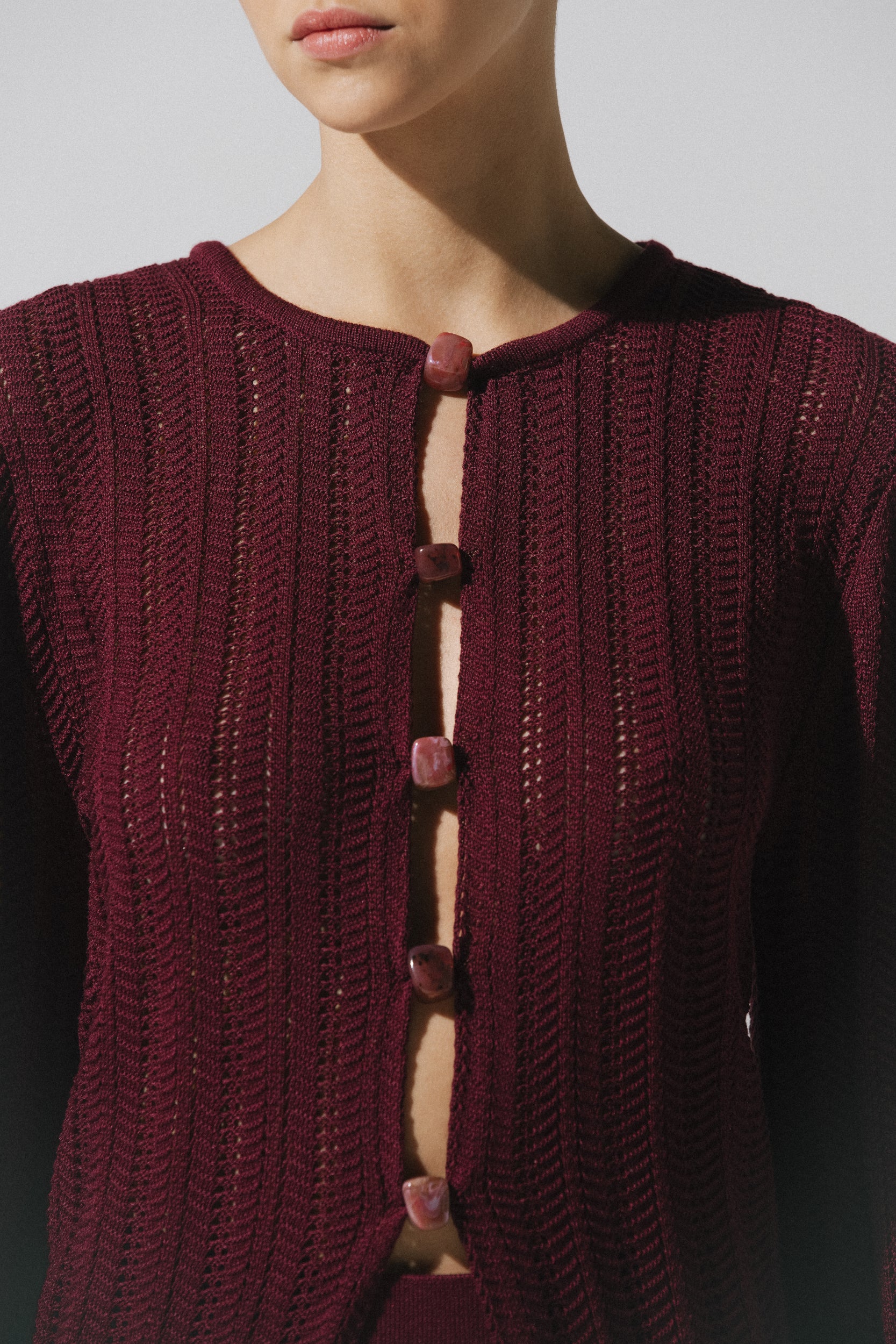 Top Corsica de Baobab en color burgundy, cuello redondo con recortes frontales y tejido semi transparente.