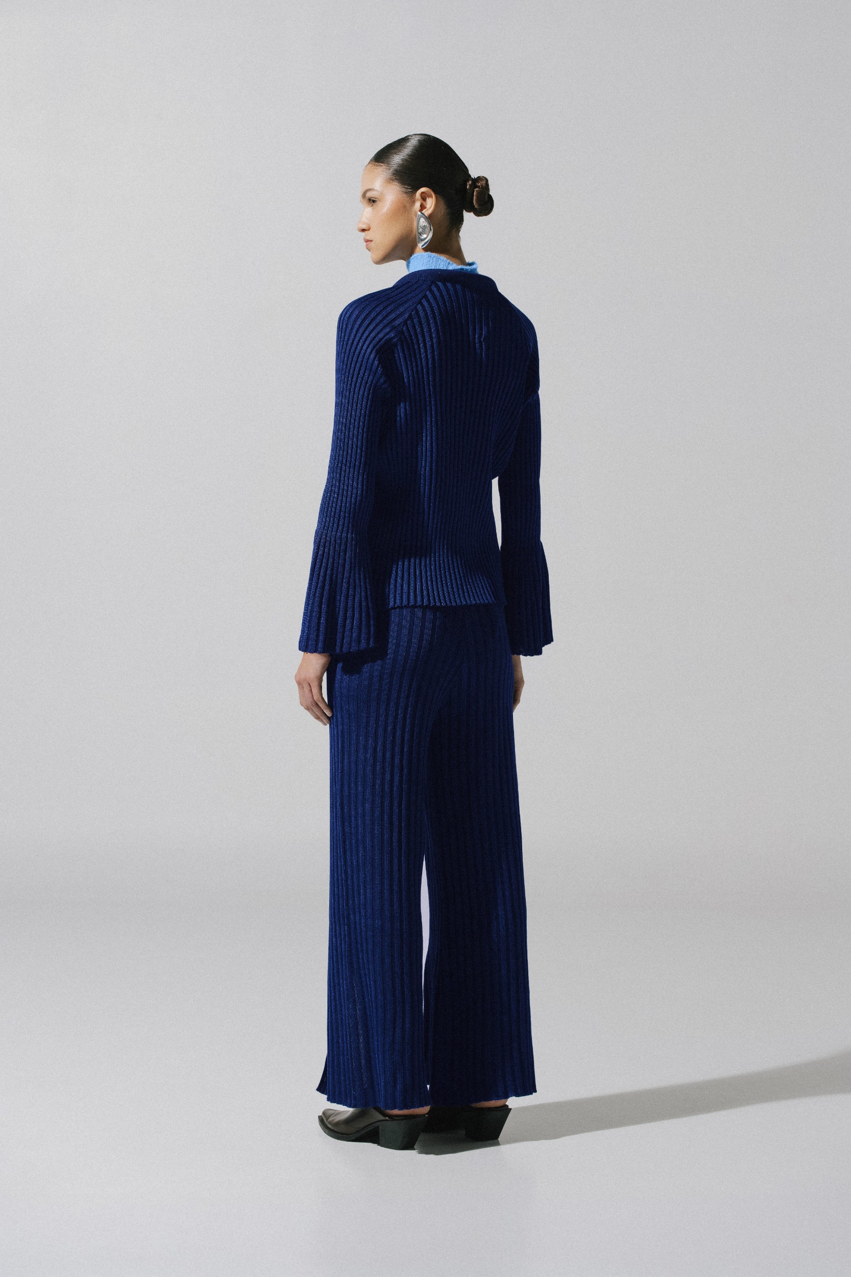 Sweater Lotus night blue en exterior urbano, manga amplia y textura acanalada.