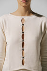 Top Kyoto de Baobab en color white cream, cuello redondo con recortes frontales y herraje decorativo.