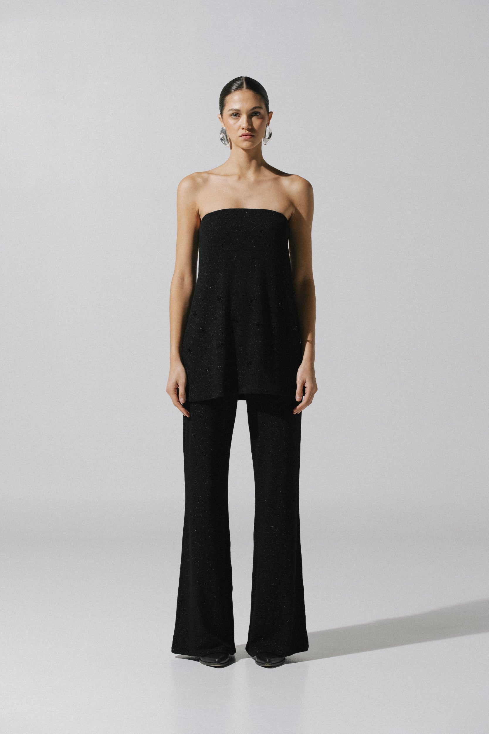 Pantalón Suzu de Baobab en tela brillante negra, pierna ancha y cintura elástica.