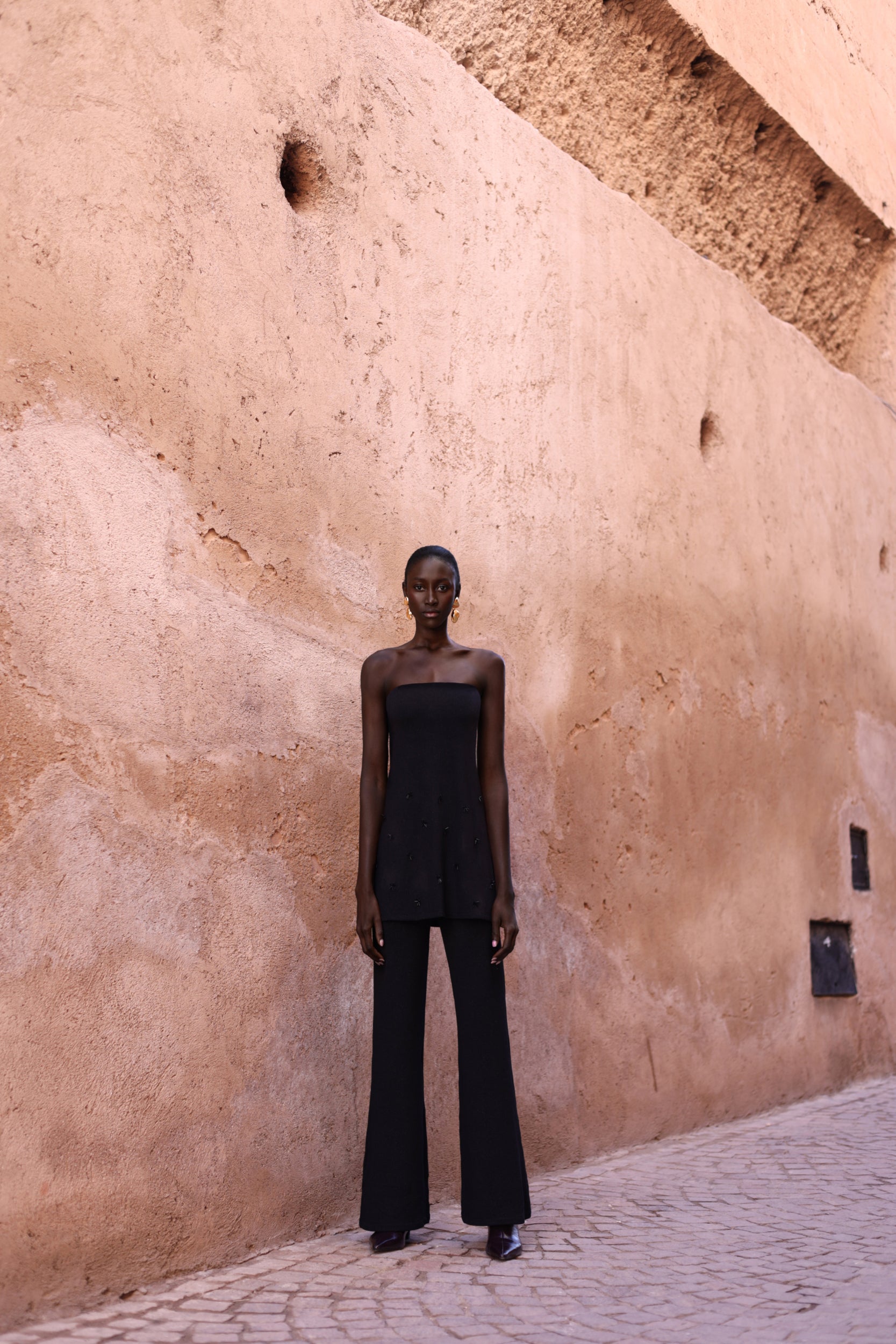 Pantalón Suzu negro, estilo wide-leg con tela brillante y cintura cómoda.