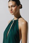 Vestido verde esmeralda Rondine con escote halter, silueta ajustada y tela brillante.